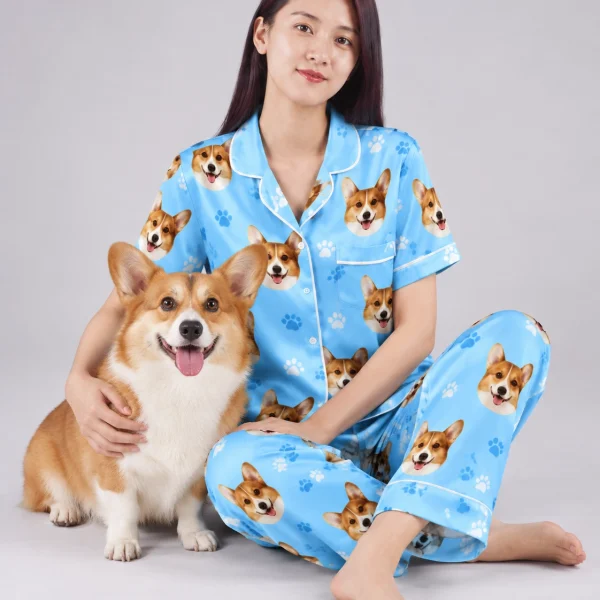 Woman in PJs with dogs on them cuddling her corgi — MyDogPics