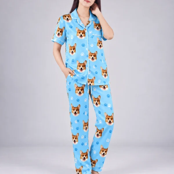 Woman posing in PJs with dogs on them, corgi faces on sky blue satin with paw prints — MyDogPics
