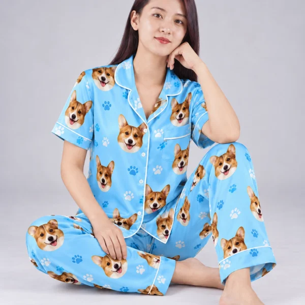 Woman sitting in PJs with dogs on them covered in corgi faces — MyDogPics