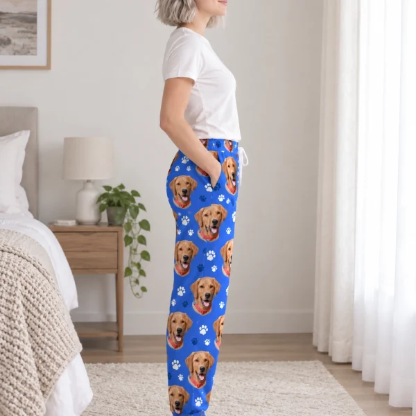 Side view of red pajama pants with golden retriever faces on royal blue paw-print fabric — MyDogPics