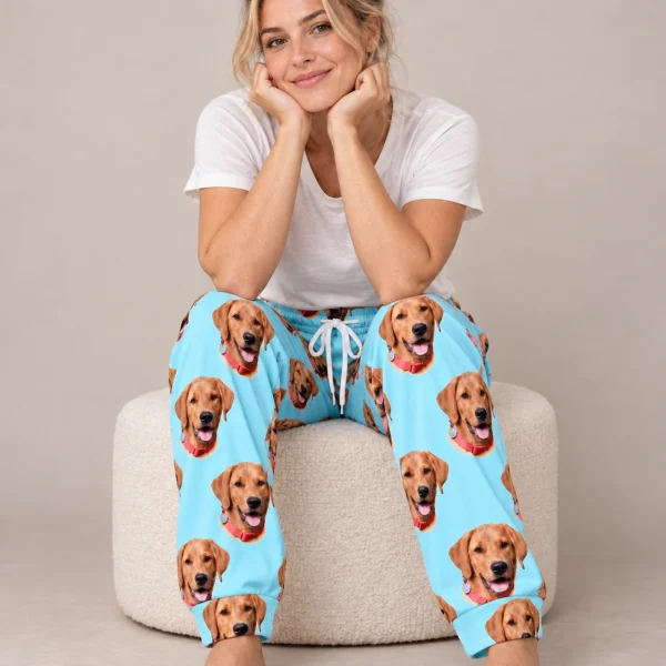 Woman sitting in red pajama pants covered in golden retriever faces — MyDogPics