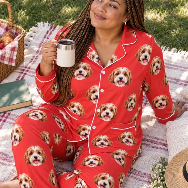 Woman sitting in red pajamas covered in doodle puppy faces — MyDogPics