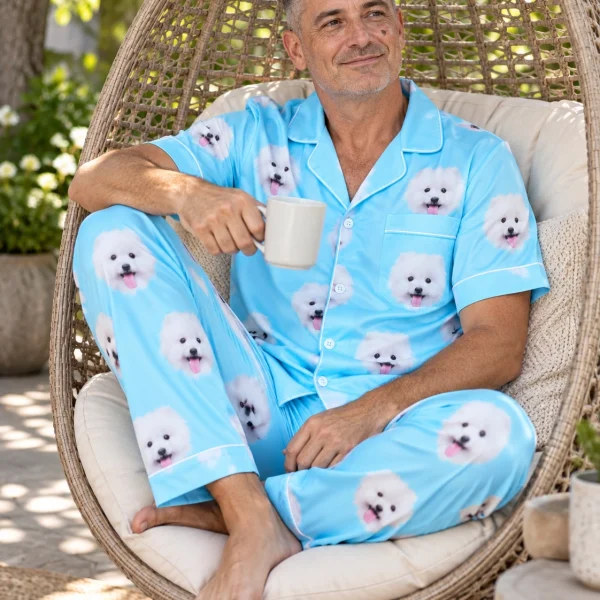 Man sitting in a satin pajamas for men covered in white Pomeranian faces — MyDogPics