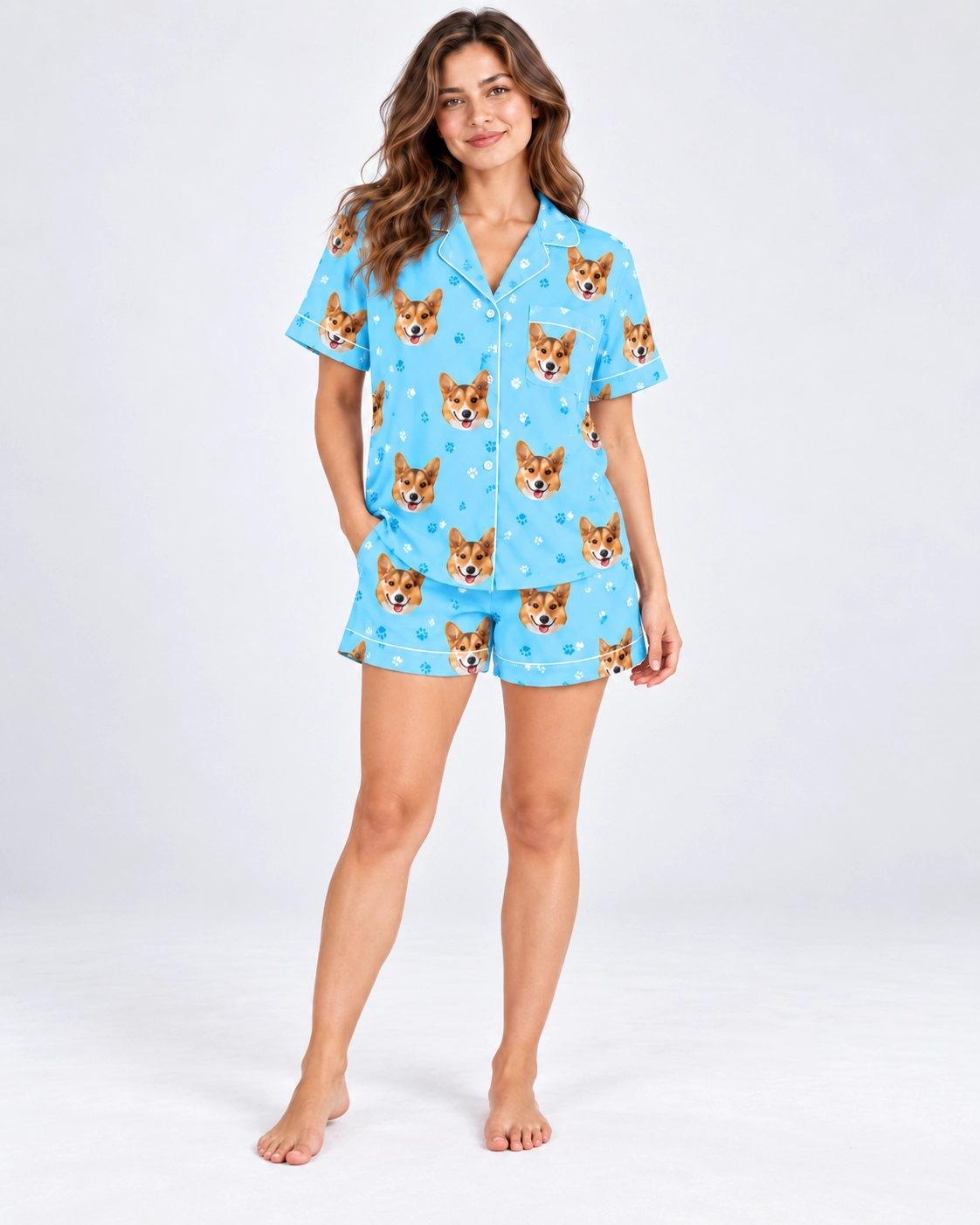Short Sleeve Satin Pajama Set – Pose | MyDogPics Woman posing in a short sleeve satin pajama set, corgi faces on sky blue satin with white piping — MyDogPics