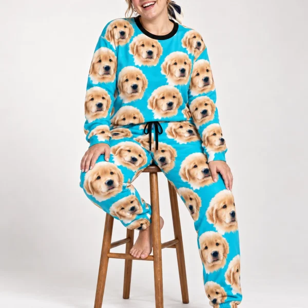 Woman sitting in a soft pajamas for women covered in golden retriever puppy faces — MyDogPics
