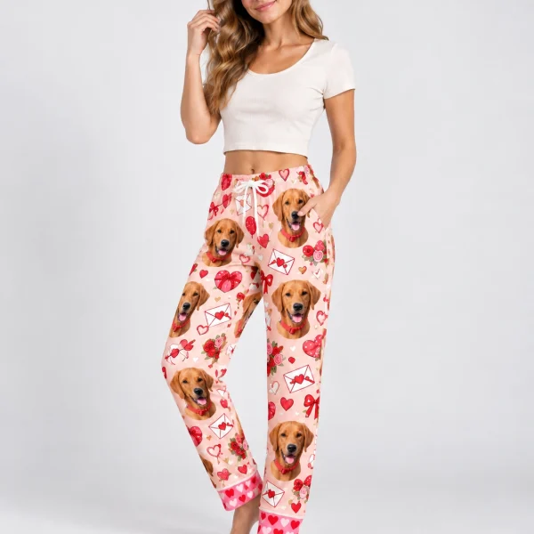 Woman posing in Valentine pajama pants, golden retriever faces on a pink Valentine hearts print — MyDogPics