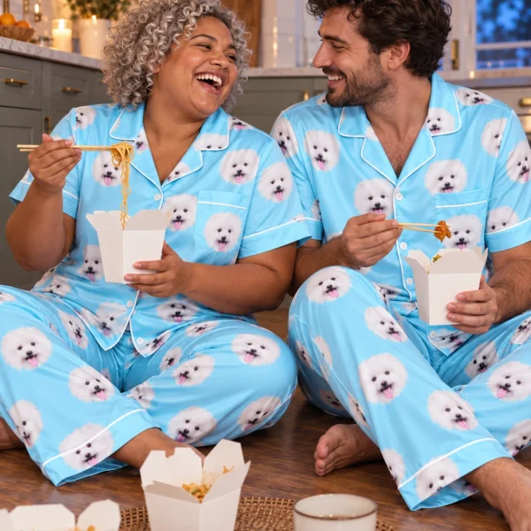 Woman and her partner in matching Valentines day pajamas with white Pomeranian faces on light blue satin — MyDogPics