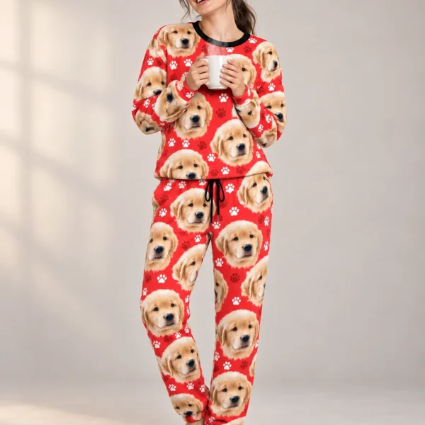 Woman wearing womens Christmas pajamas covered in golden retriever puppy faces on red paw-print fabric — MyDogPics
