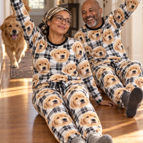 Woman and her partner in matching womens jogger pajamas with golden retriever puppy faces on white plaid fabric — MyDogPics