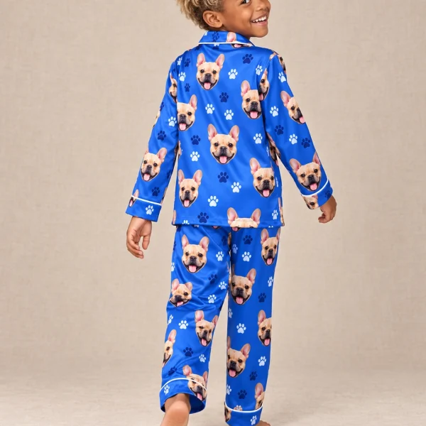 Boy wearing birthday boy pajamas covered in fawn French bulldog faces on royal blue paw-print satin — MyDogPics