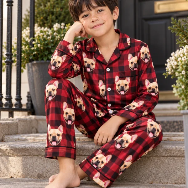 Boy sitting in boys Christmas pajamas covered in fawn French bulldog faces — MyDogPics