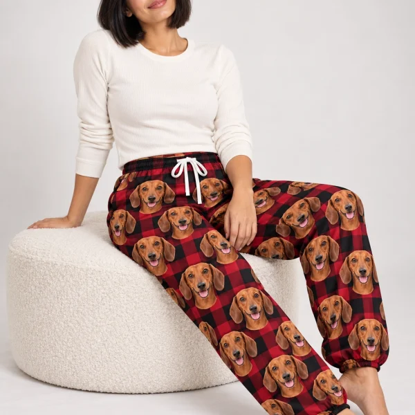 Woman sitting in dachshund Christmas pants covered in red smooth-coated Dachshund faces — MyDogPics