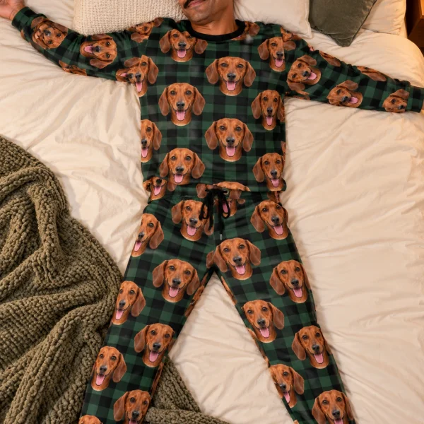 Man posing in a dachshund pajama set, red smooth-coated Dachshund faces on green plaid fabric — MyDogPics