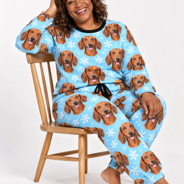 Woman sitting in dachshund winter pajamas covered in red smooth-coated Dachshund faces — MyDogPics