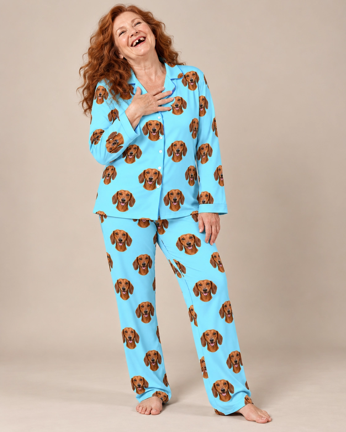 Doxie Pajamas – Front View, Light Blue | MyDogPics Woman wearing doxie pajamas covered in red smooth-coated Dachshund faces on light blue fabric — MyDogPics