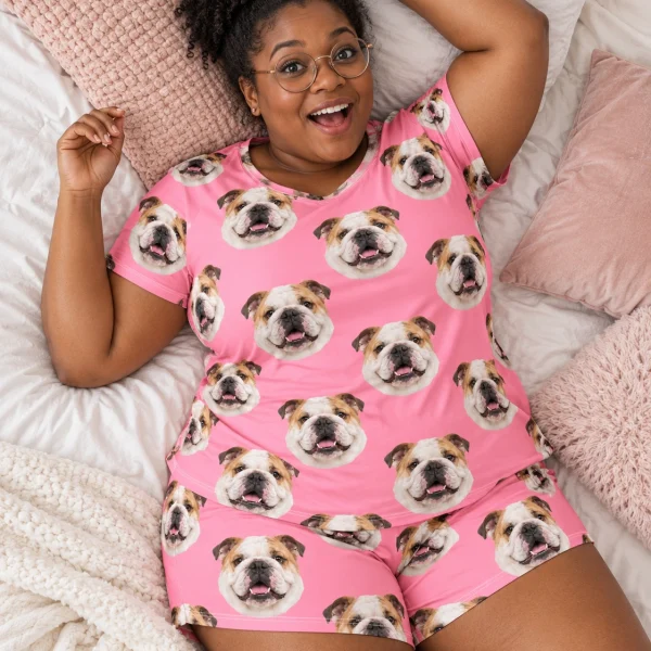 Woman posing in an english bulldog lounge set, white-and-fawn English Bulldog faces on pink fabric — MyDogPics