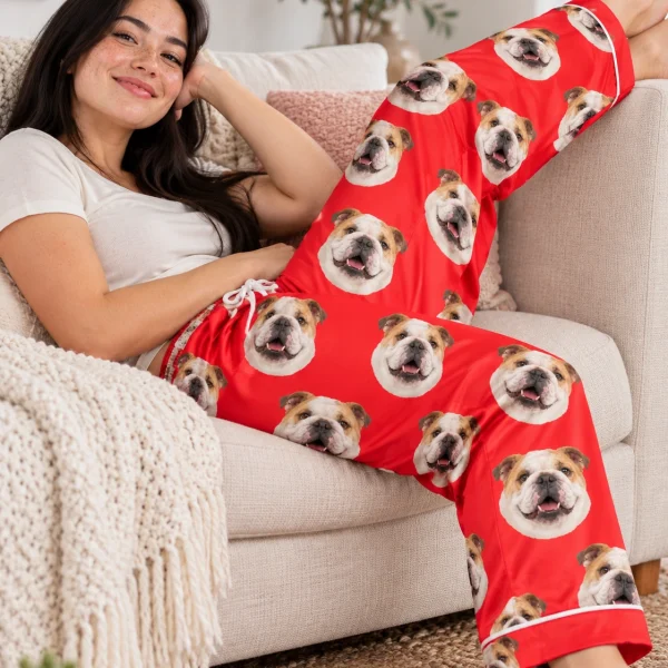 Woman posing in english bulldog Valentine pajamas, white-and-fawn English Bulldog faces on red satin — MyDogPics