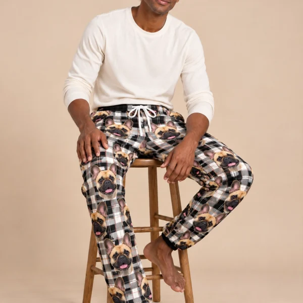 Man sitting in French bulldog pajama pants covered in fawn French Bulldog faces — MyDogPics