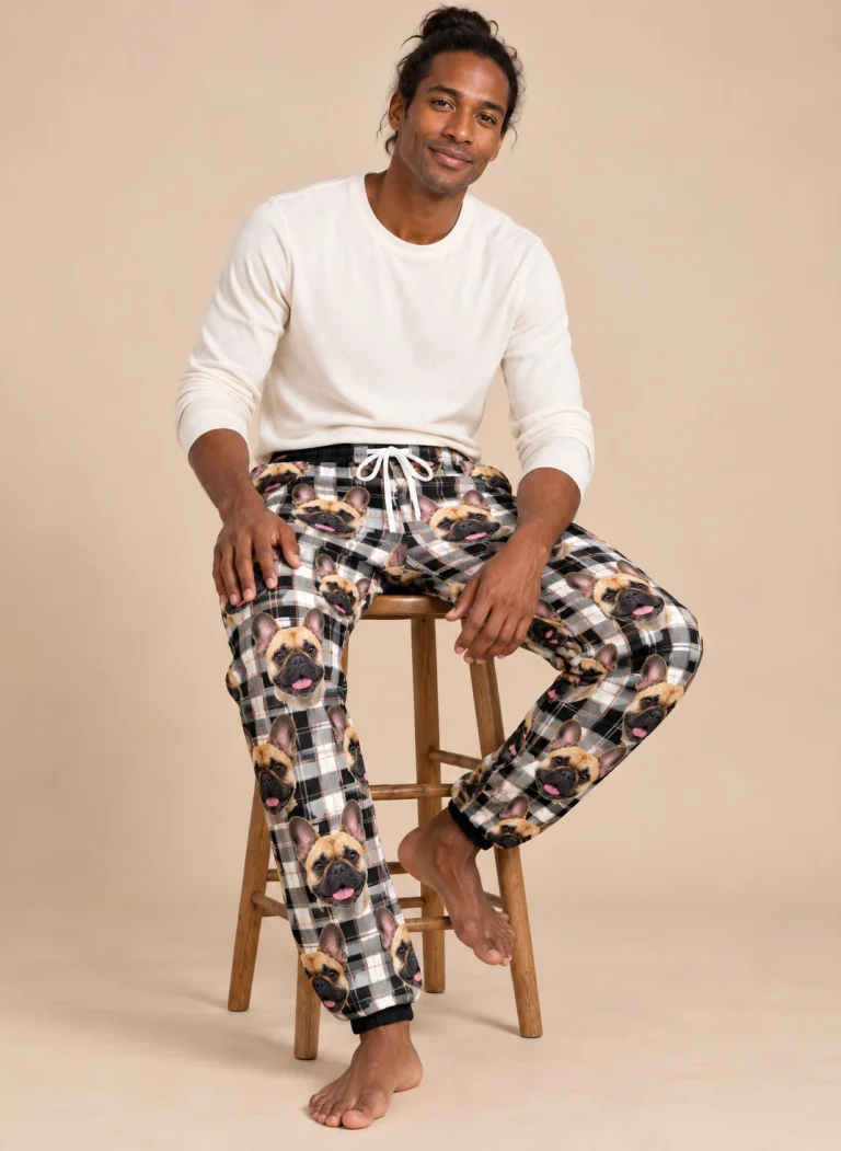 Man sitting in French bulldog pajama pants covered in fawn French Bulldog faces — MyDogPics