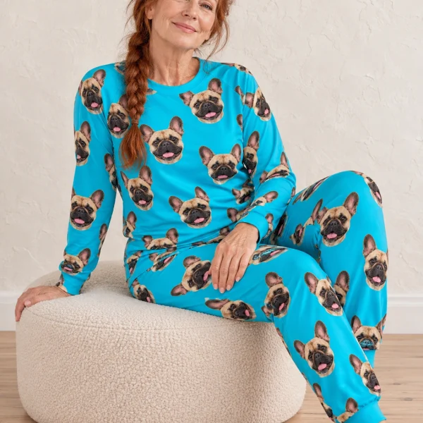 Woman sitting in a French bulldog pajamas for adults covered in fawn French Bulldog faces — MyDogPics