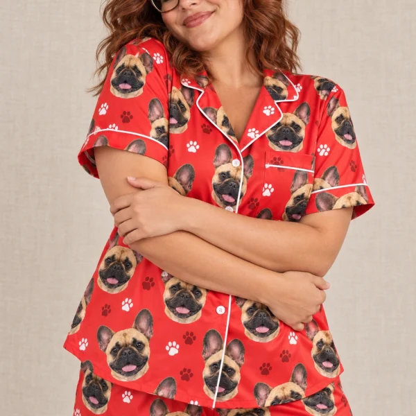 Woman posing in a French bulldog Valentines day pajama set, fawn French Bulldog faces on red paw-print satin — MyDogPics