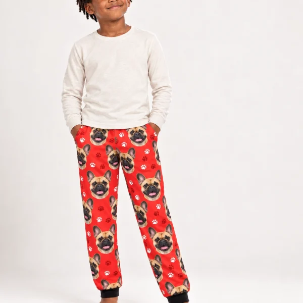 Boy wearing kids French bulldog pajama pants covered in fawn French Bulldog faces on red paw-print fabric — MyDogPics
