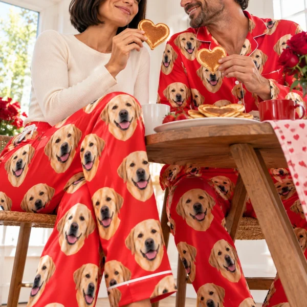 Woman and her partner in matching labrador Valentine pajamas with yellow Labrador Retriever faces on red satin — MyDogPics