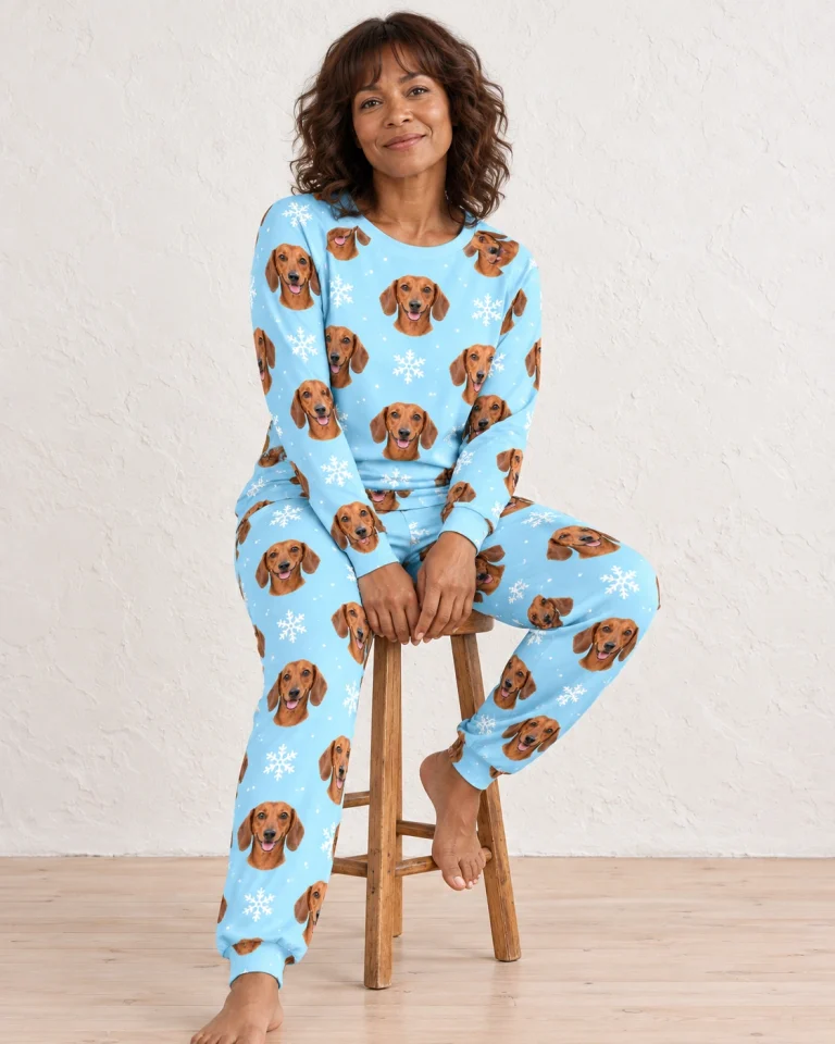 Woman sitting in matching dachshund pajamas covered in red smooth-coated Dachshund faces — MyDogPics