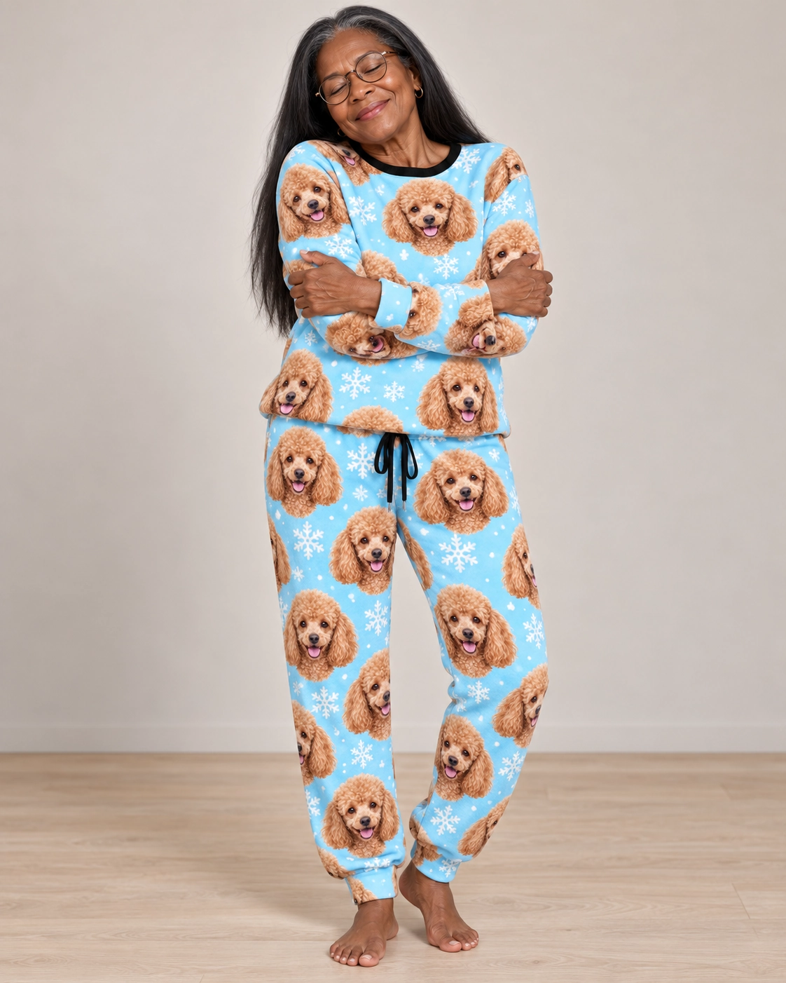 Poodle Winter Pajamas – Front View, Light Blue Snowflake | MyDogPics Woman wearing poodle winter pajamas covered in apricot Poodle faces on light blue snowflake fabric — MyDogPics