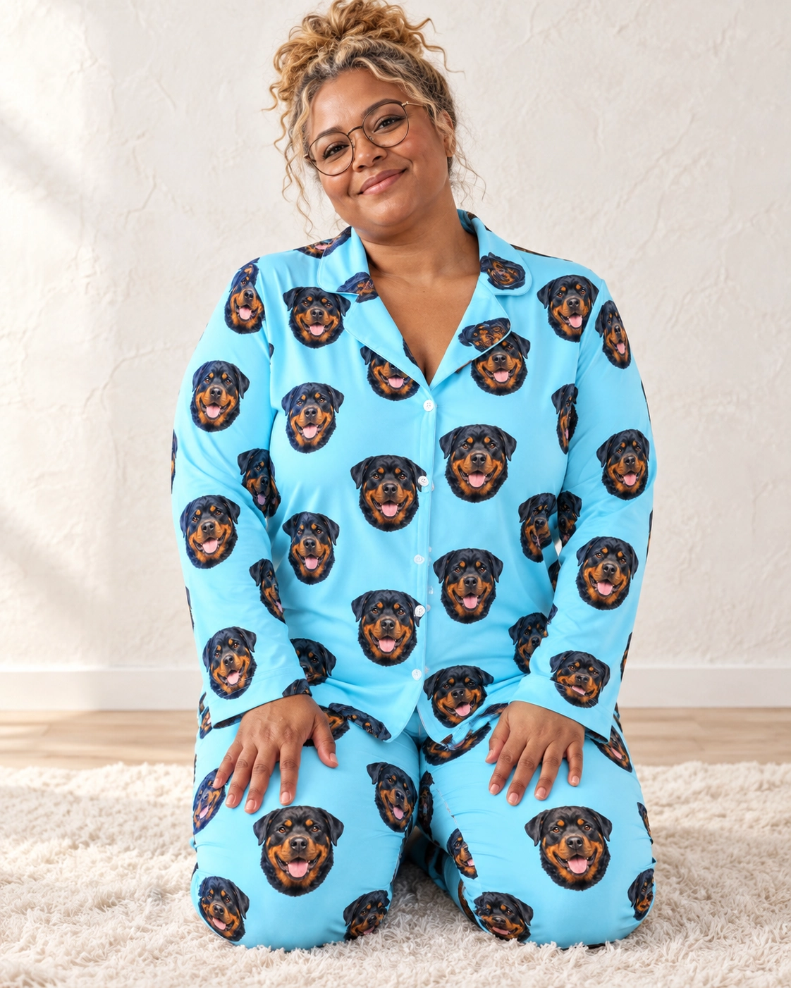 Rottie Pajamas – Sitting, Light Blue | MyDogPics Woman sitting in rottie pajamas covered in black-and-mahogany Rottweiler faces — MyDogPics