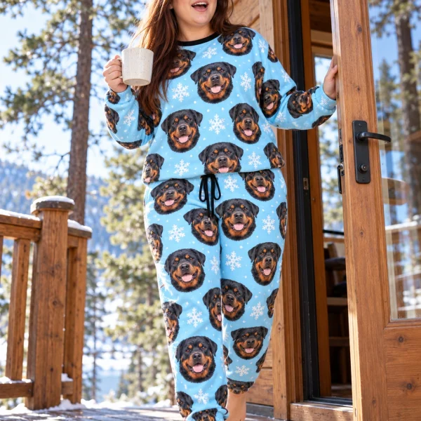 Woman posing in rottweiler winter pajamas, black-and-mahogany Rottweiler faces on light blue snowflake fabric — MyDogPics