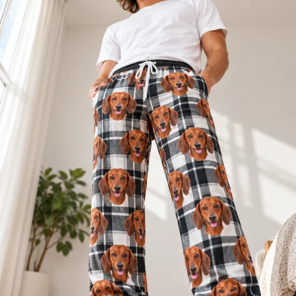 Man wearing weiner dog pajama pants covered in red smooth-coated Dachshund faces on white plaid fabric — MyDogPics