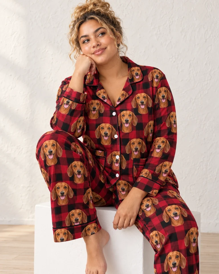 Woman sitting in wiener dog Christmas pajamas covered in red smooth-coated Dachshund faces — MyDogPics