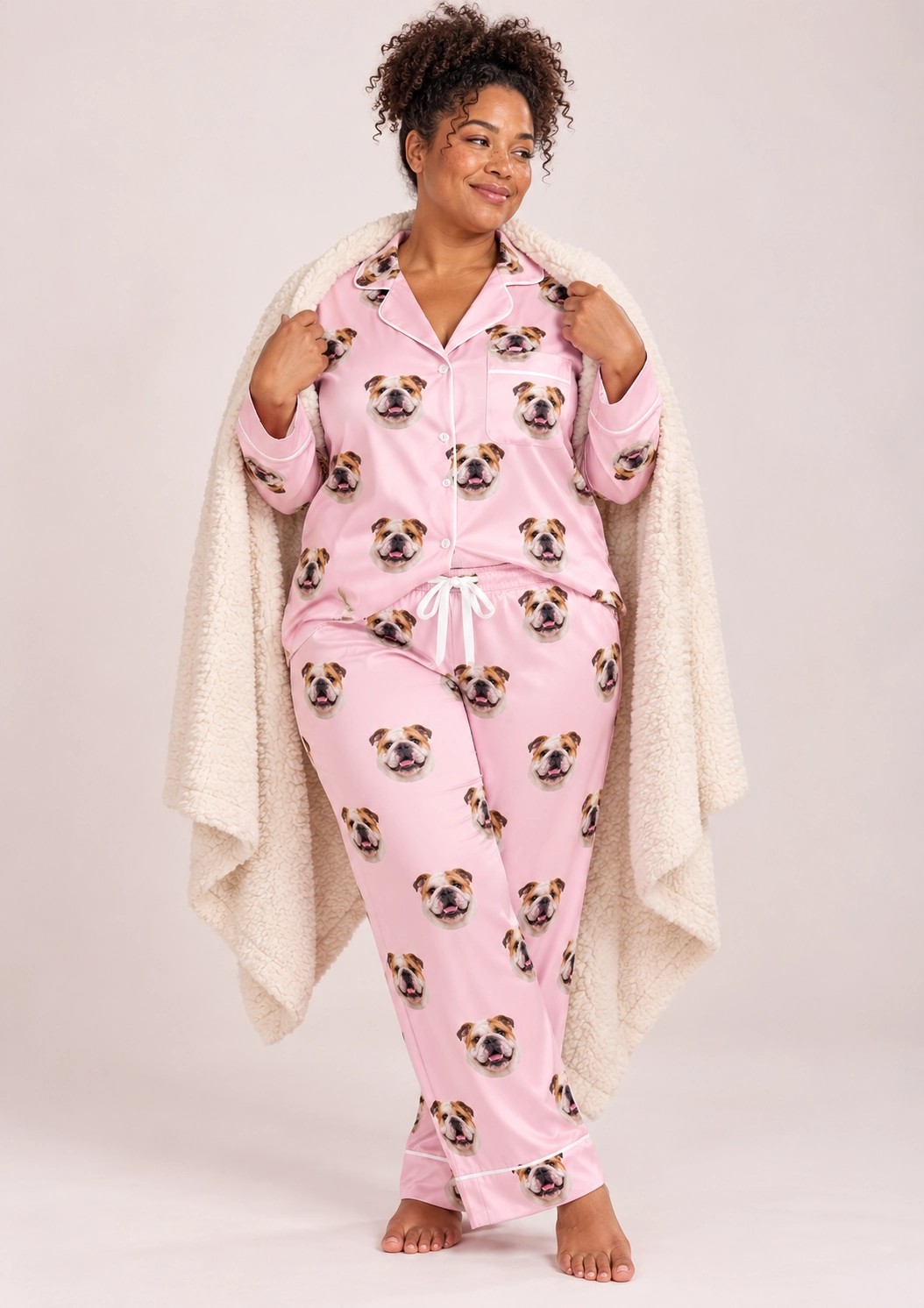 Women’s English Bulldog Pajamas – Front View, Blush Pink | MyDogPics Woman wearing womens english bulldog pajamas covered in white-and-fawn English Bulldog faces on blush pink satin — MyDogPics